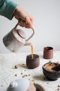 person pouring coffee on brown cup - benefits of ginger tea