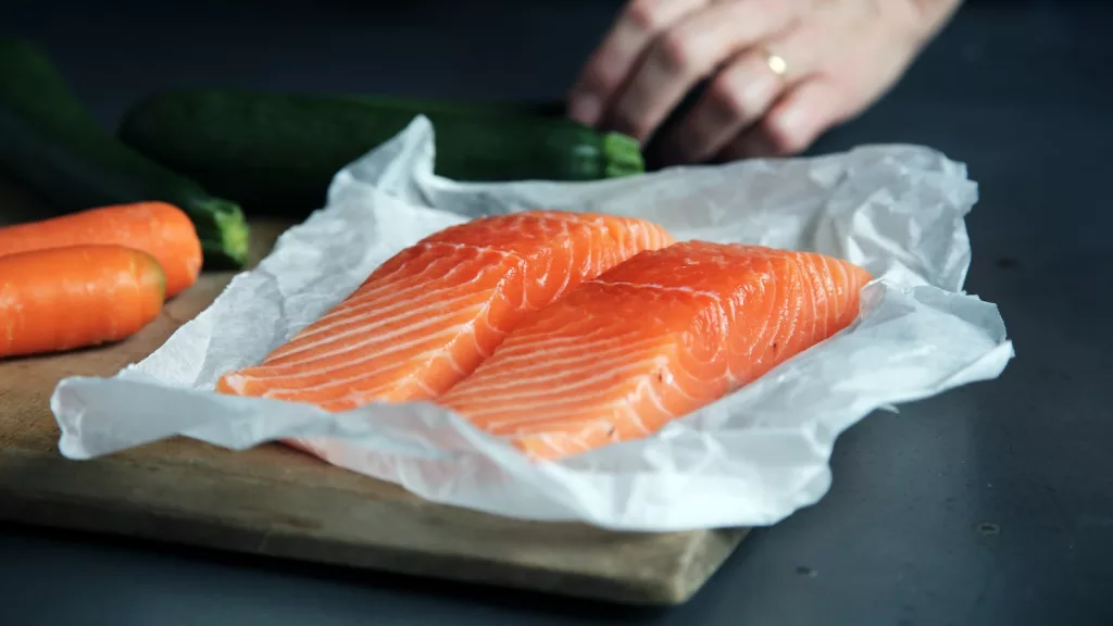 raw fish meat on brown chopping board, fatty fish for healthy hair growth