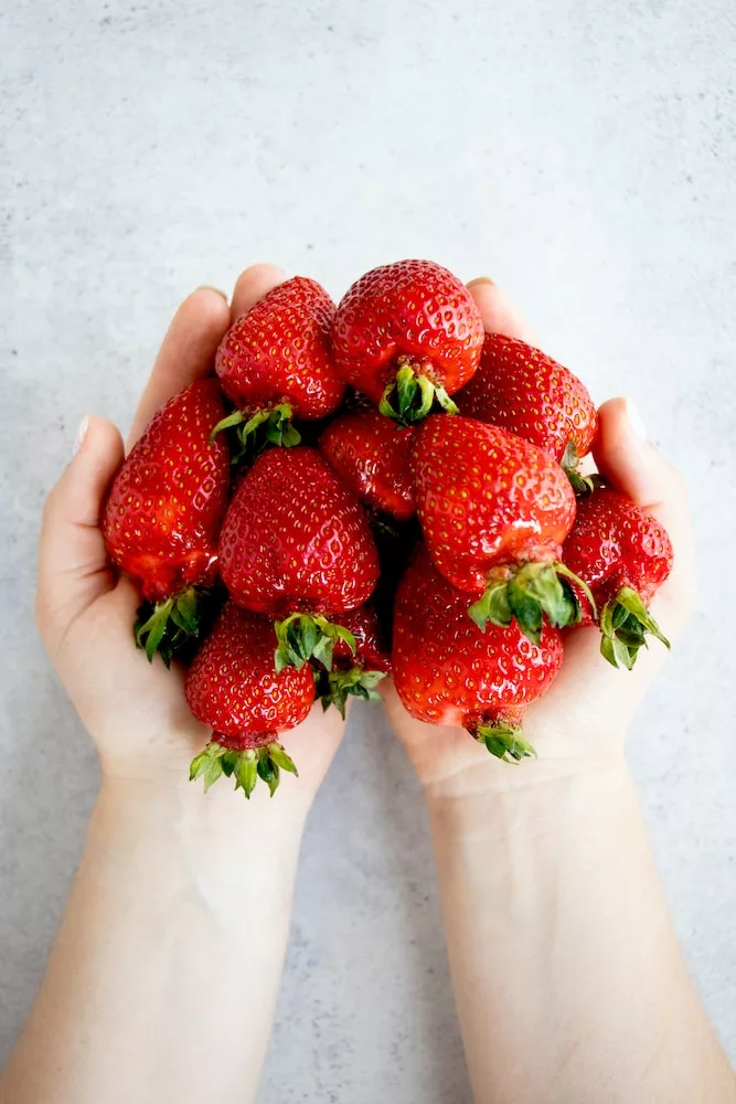strawberries on persons hand, strawberries health benefits