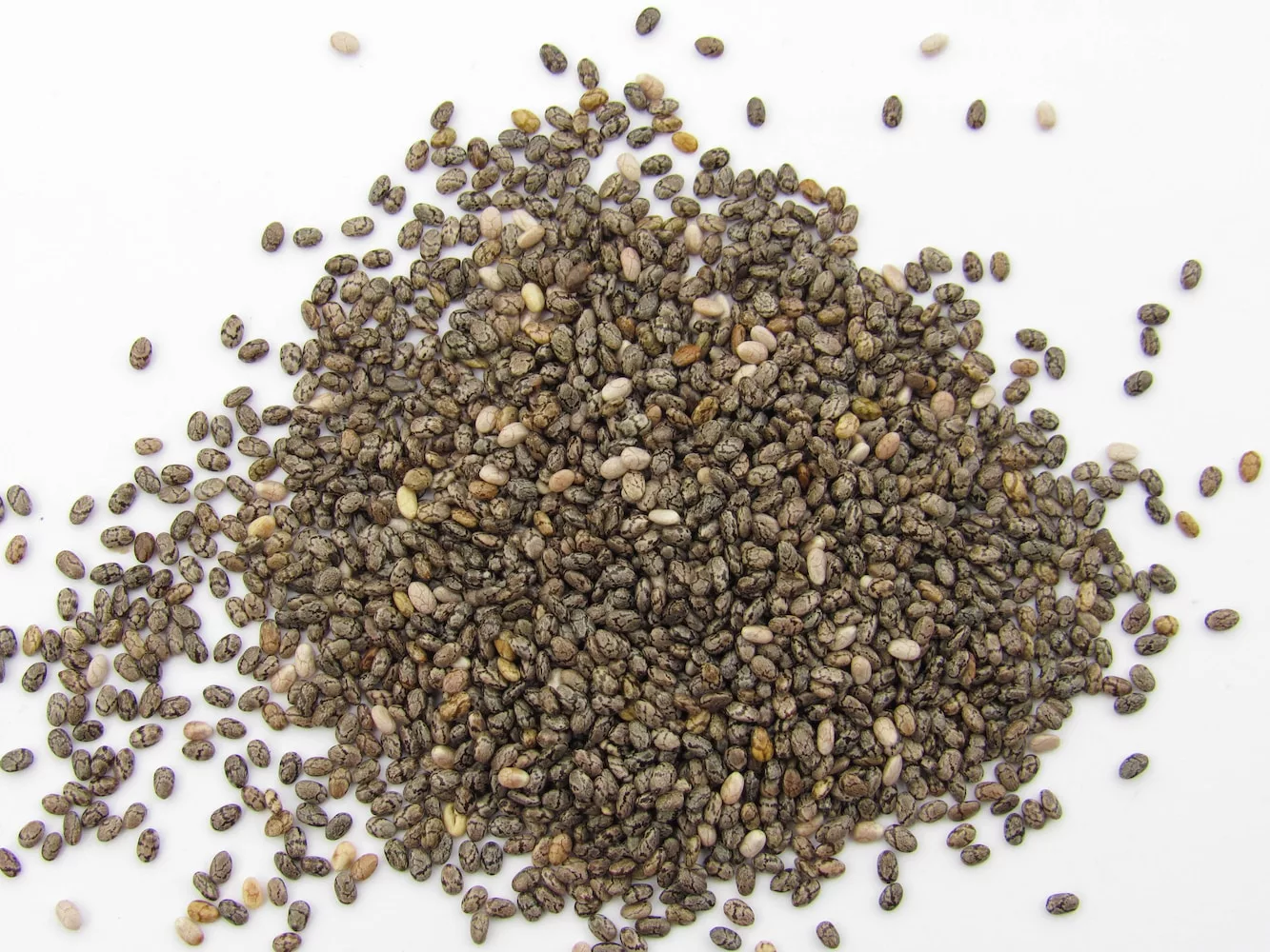 a pile of seeds on a white surface, chia seeds, fiber-rich foods