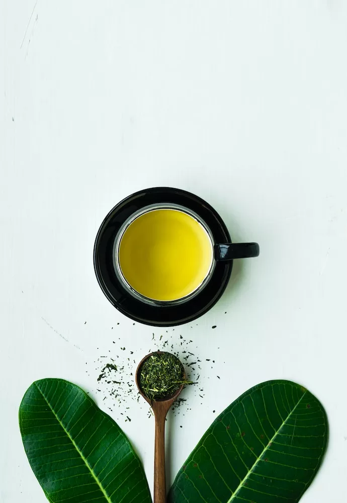 black ceramic mug with brown liquid inside, green tea to boost your immune system