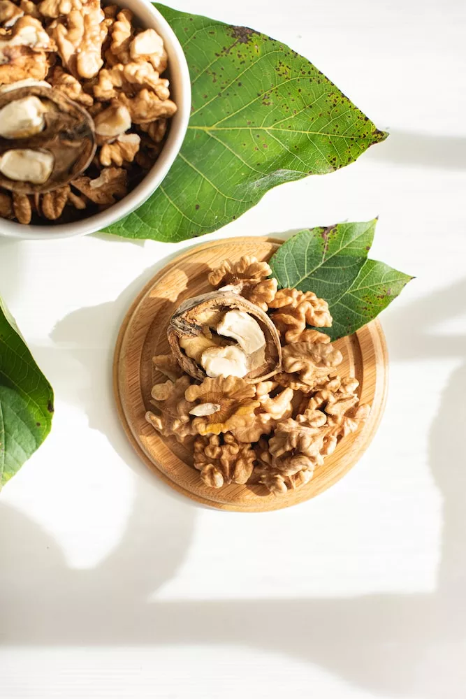 brown wooden bowl with brown nuts, walnuts promote a healthy liver