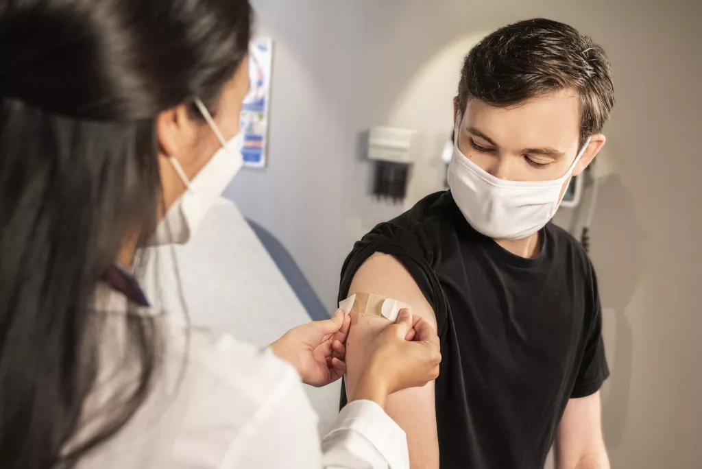 woman in black crew neck t-shirt wearing white face mask, get vaccine to preventing bronchitis