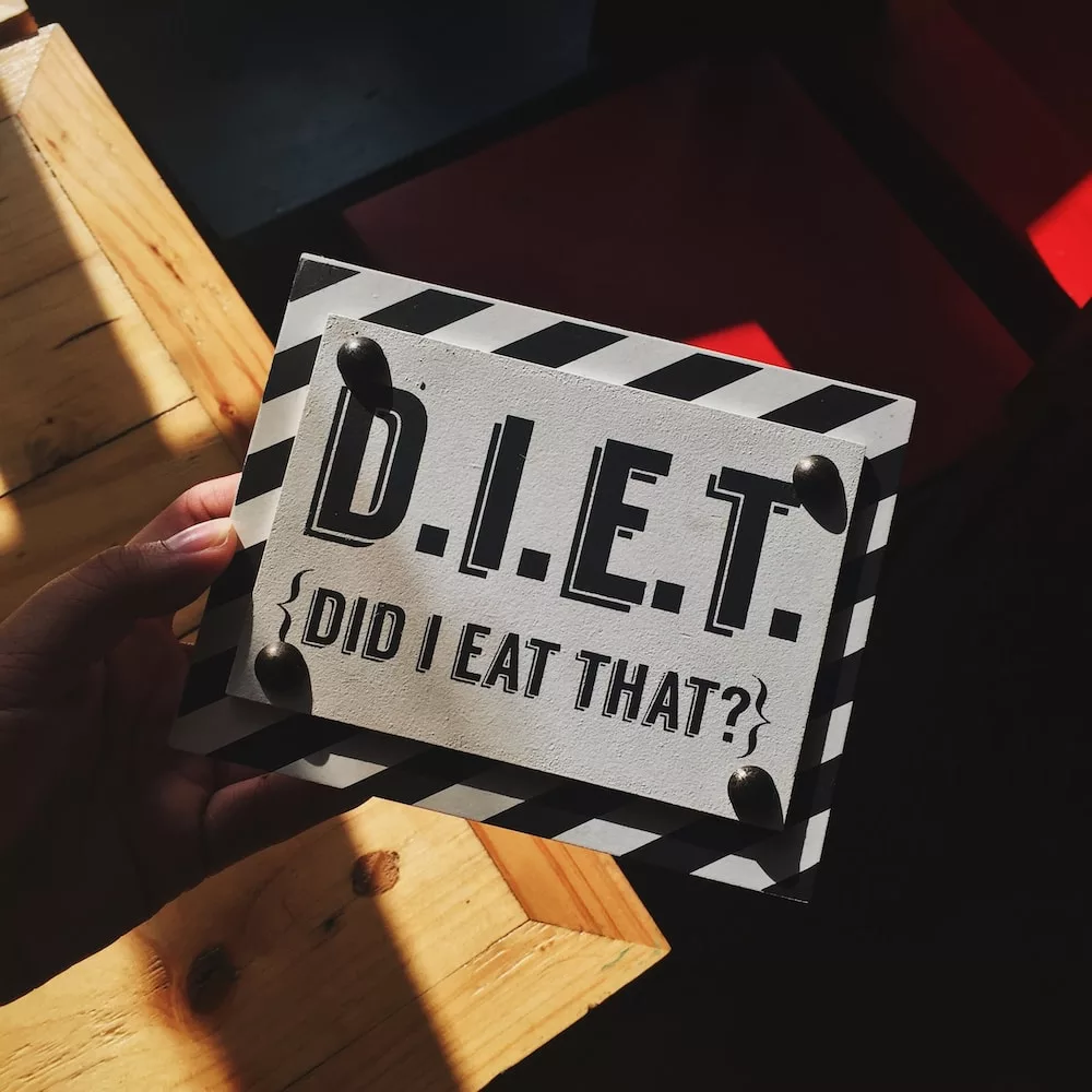 person holding DIET quote board, diet is one of the ways to avoid acid reflux