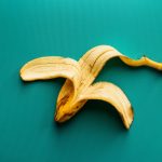 a peeled banana sitting on top of a green surface
