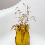 grasses in yellow translucent glass vase