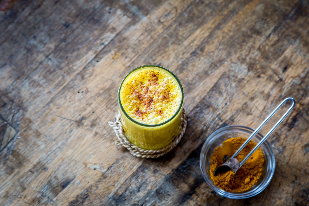 clear drinking glass full of orange liquid | turmeric milk recipe for cold and cough