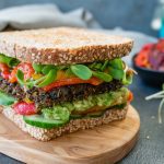 burger with tomato and lettuce on brown wooden round plate | quick vegan dinner recipes