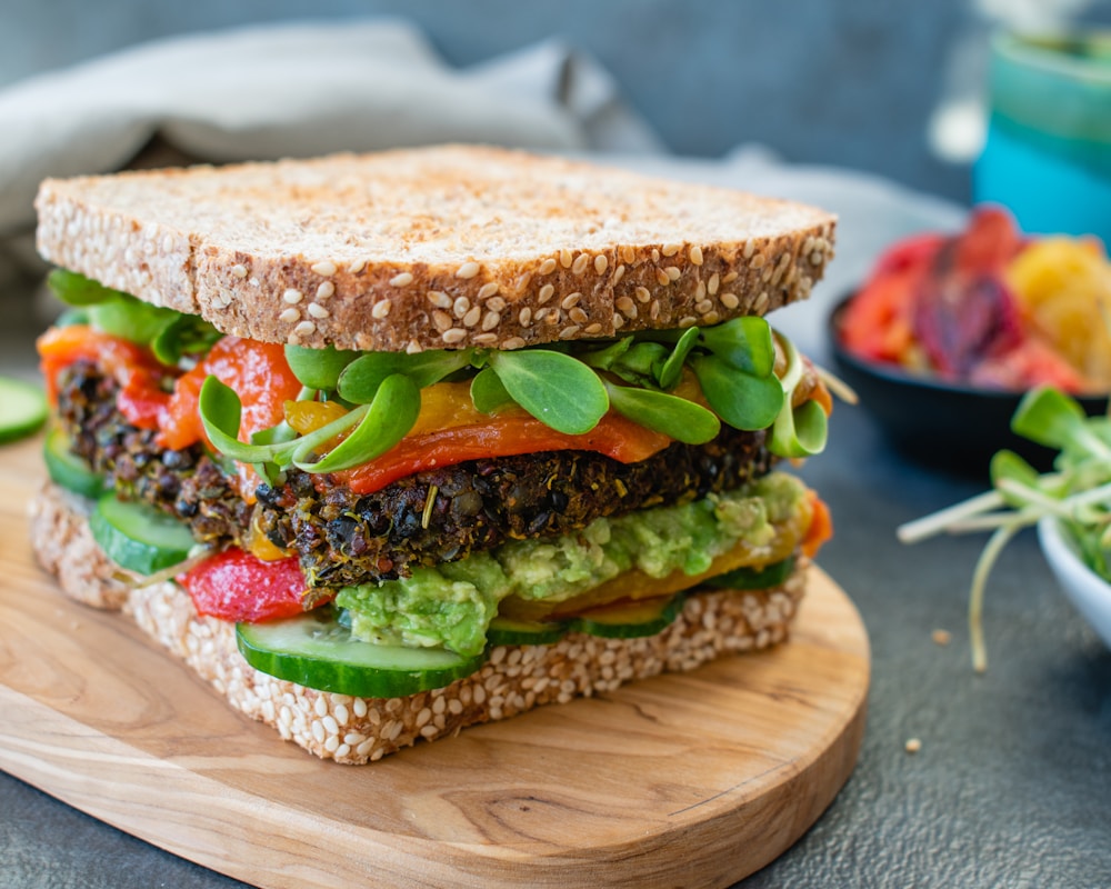 burger with tomato and lettuce on brown wooden round plate | quick vegan dinner recipes