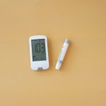 a thermometer and a pen on a yellow surface | signs of low blood sugar in adults