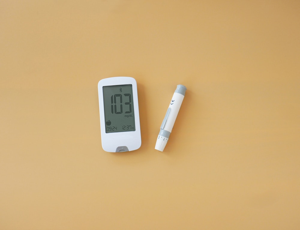 a thermometer and a pen on a yellow surface | signs of low blood sugar in adults